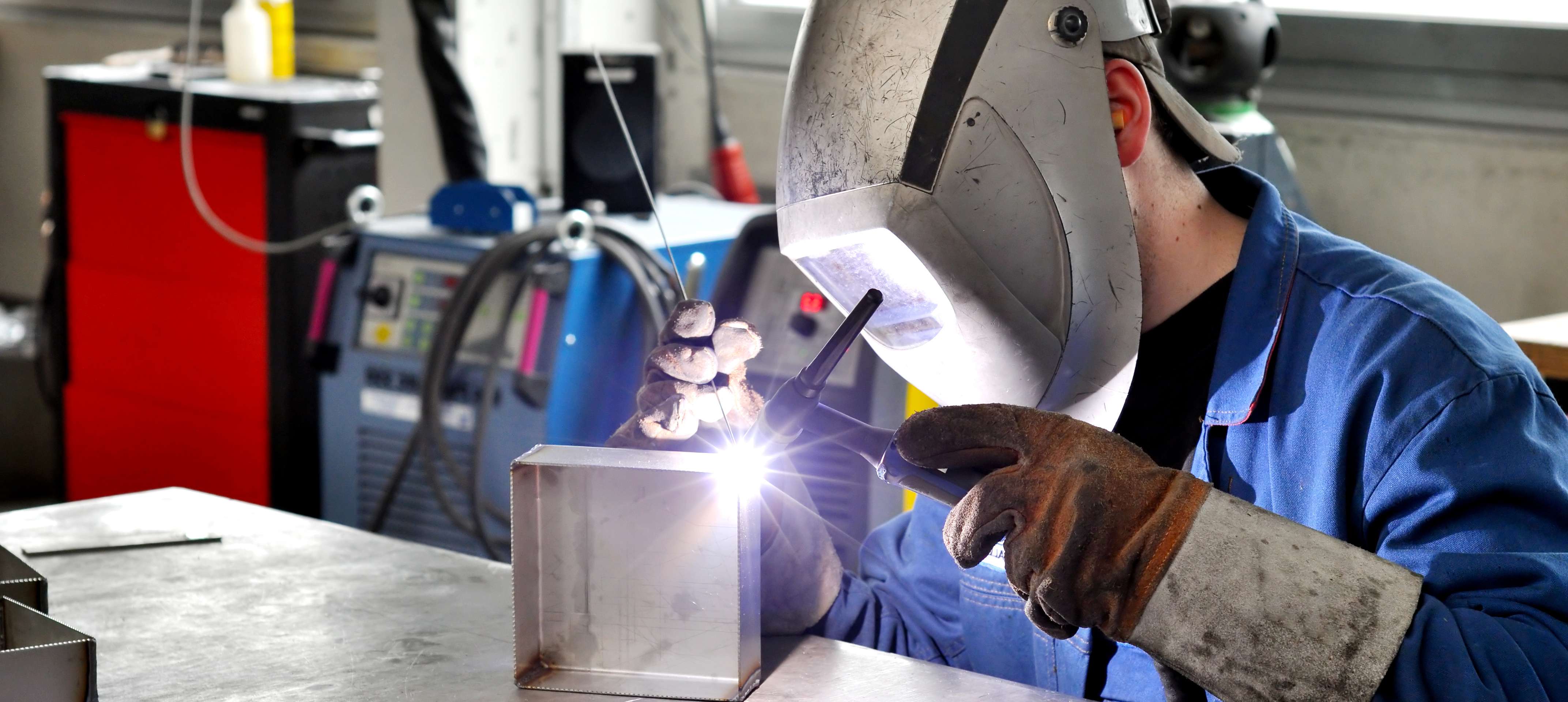 Person welding a metal part.